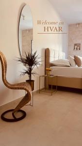 a bedroom with a bed and a mirror and a chair at Oleander Apartment & Room Centar in Hvar