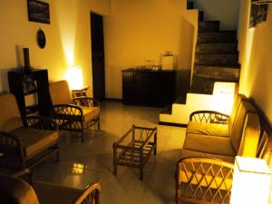 un salon avec des canapés et des chaises ainsi qu'un escalier dans l'établissement Home Capybara Stay, à Mindo