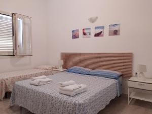 um quarto com 2 camas e toalhas em Lucy beach em Torre Lapillo