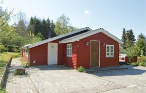 a red shed with a white door in a driveway at 3 Bedroom Cozy Home In Fårvang in Fårvang