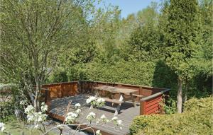 a wooden deck with a picnic table in a garden at 3 Bedroom Cozy Home In Fårvang in Fårvang +14 photos