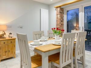 a dining room with a wooden table and chairs at Lily J Rose in Braunston