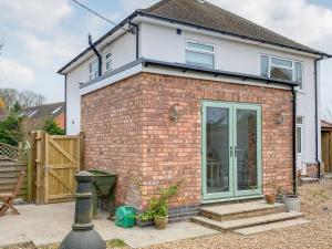 a brick house with a sliding glass door at Lily J Rose in Braunston