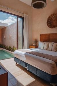 a bedroom with a bed and a swimming pool at Casa Mara 45 in Mérida