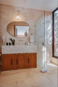 a bathroom with a shower and a sink and a mirror at Casa Mara 45 in Mérida