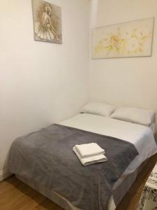 a bedroom with a bed with two towels on it at Double Room Central Location 2 in Plumstead