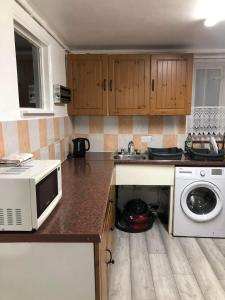 a kitchen with a microwave and a washing machine at Double Room Central Location 2 in Plumstead