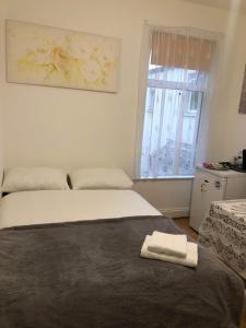 a bedroom with a bed with a towel on it at Double Room Central Location 2 in Plumstead