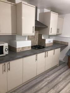 cocina con armarios blancos y encimera en Double Room Central Location 2 en Plumstead