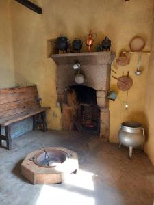 a room with a fireplace and a table and a toilet at Casa do Outeiro in Meda