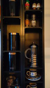 a black cabinet with a tea kettle and dishes in it at Studio White Bears in Akureyri