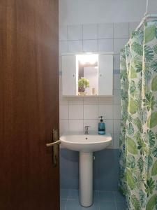 a bathroom with a sink and a mirror and a shower curtain at Φρίντα στο κέντρο της Ορεστιάδας in Orestiada