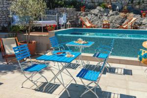 a table and chairs next to a swimming pool at Boutique Hotel Capitano in Herceg-Novi