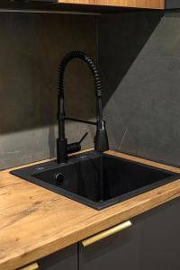 a black kitchen sink with a black faucet at Awesome Apartment Bucharest in Bucharest +30 photos