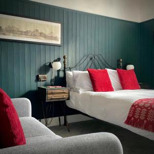 a bedroom with a bed with red pillows and a chair at Crafnant House - Bed & Breakfast in Trefriw