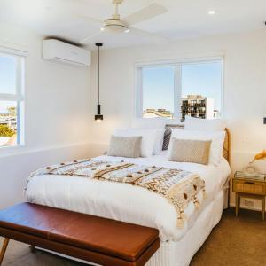 a white bedroom with a large bed and two windows at Spectacular views over Albert Park in Melbourne