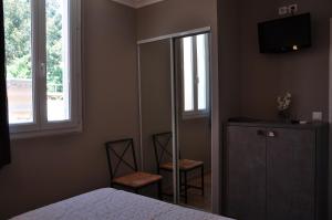 - une chambre avec un lit, deux chaises et un miroir dans l'établissement Hotel de la Plage, au Lavandou