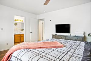 Schlafzimmer mit einem Bett und einem Flachbild-TV in der Unterkunft Groovy Getaway in Grover Beach