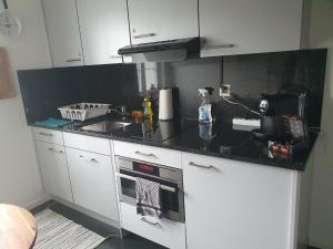 a kitchen with white cabinets and a black counter top at Bastis Luxury Studios - Free Parking in Lucerne