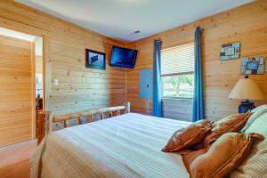 een slaapkamer met een bed met houten wanden en een televisie bij Cozy Columbia Cabin with Shared Lake Dock! in Columbia