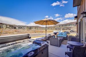 a hot tub on a patio with an umbrella at Park City Vacation Rental with Private Hot Tub! in Keetley Junction