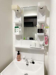 a white bathroom with a sink and a mirror at 403 Oshiage sta 3mins walk! Wi-Fi & Elevator 4pax in Tokyo