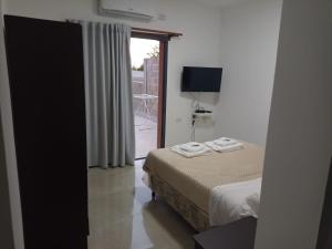 a bedroom with a bed and a sliding glass door at Las Cañas in Paraná