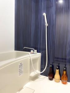 a bathroom with a bath tub with bottles on the floor at 403 Oshiage sta 3mins walk! Wi-Fi & Elevator 4pax in Tokyo +28 photos