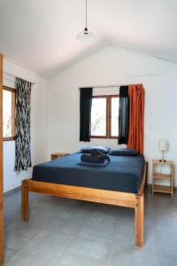 1 dormitorio con 1 cama con sábanas azules y ventanas en 1 Bedroom G-Land Burnt Toast Surfcamp, en Nosara