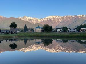 a reflection of mountains in a body of water at Little Alaskan Guest House in Hakuba