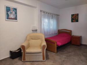 sypialnia z łóżkiem, krzesłem i łóżkiem w obiekcie Sol y Monte w mieście Capilla del Monte