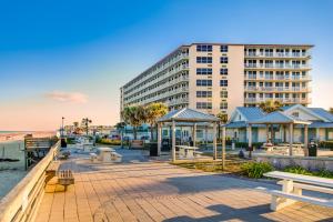 a large building next to a beach with benches at Harbour Beach Resort 611 in Daytona Beach