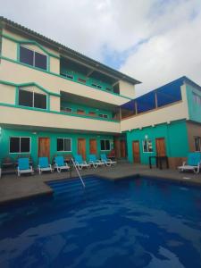 a house with a swimming pool in front of a building at The Lookout Beach Hotel in San Lorenzo