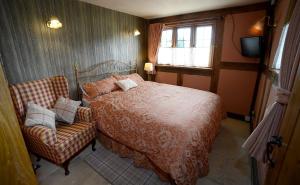 a bedroom with a bed and a chair and a television at FLETCHERS HALL COVERED POOL Heated in Freckleton