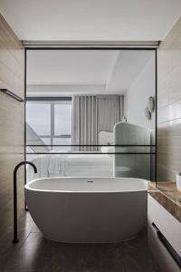 uma grande banheira branca na casa de banho em The Jewel, A designer Condo in the Sky em Gold Coast