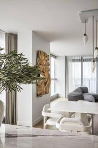 uma sala de estar branca com uma mesa e cadeiras em The Jewel, A designer Condo in the Sky em Gold Coast