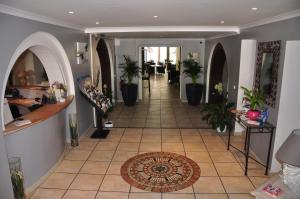 a hallway with potted plants and a tile floor at Hotel de la Plage in Le Lavandou