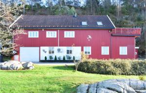 una casa rossa con un garage bianco di Gorgeous Apartment In Lyngdal With Kitchen a Lyngdal
