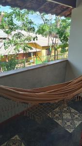 a hammock on a balcony with a view of a building at Solar dos Ipês in Serra do Cipo