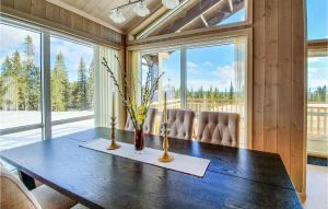 uma sala de jantar com uma mesa com cadeiras e janelas em Beautiful Home In Lillehammer With Sauna em Lillehammer