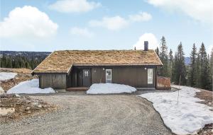 een klein huis op een heuvel met sneeuw eromheen bij Beautiful Home In Lillehammer With Sauna in Lillehammer