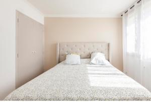biała sypialnia z dużym łóżkiem z 2 poduszkami w obiekcie Appartement logement entiers w mieście Rodez