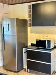 a kitchen with a stainless steel refrigerator and a microwave at Pousada serrano in Monte Verde
