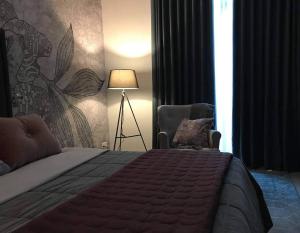 1 dormitorio con cama, lámpara y silla en Luxury apartment - Jacuzzi, pool & private terrace, en San Julián