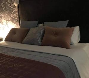 een bed met verschillende kussens erop bij Luxury apartment - Jacuzzi, pool & private terrace in St Julian's