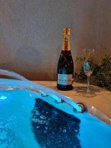 - une bouteille de vin et un verre à côté du bain à remous dans l'établissement Luxury apartment - Jacuzzi, pool & private terrace, à San Ġiljan