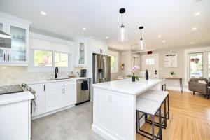 a kitchen with white cabinets and a living room at The Newark House in Niagara-on-the-Lake