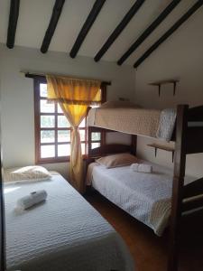 1 dormitorio con 2 literas y ventana en ALMANIK en Villa de Leyva