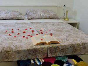 un letto con un libro e rose rosse sopra di Apartments by the sea Preko, Ugljan - 21319 a Preko (Oltre)