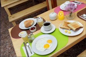 uma mesa com ovos e torradas e café em Bear Packer Hostel em Cusco